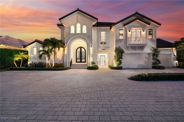 mediterranean / spanish house with a garage and french doors