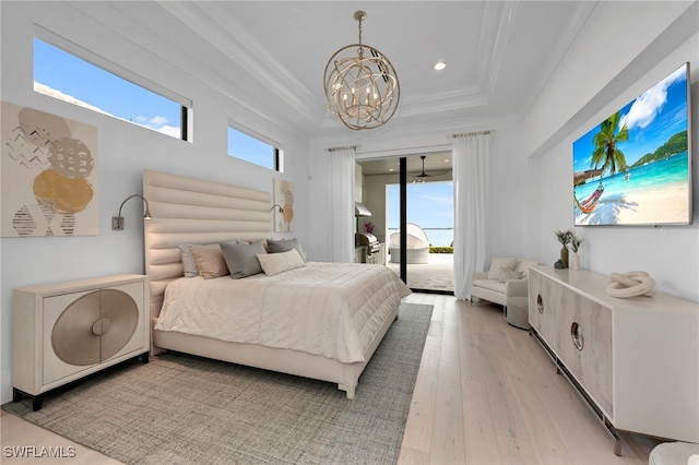 bedroom with a raised ceiling, access to exterior, a chandelier, and multiple windows