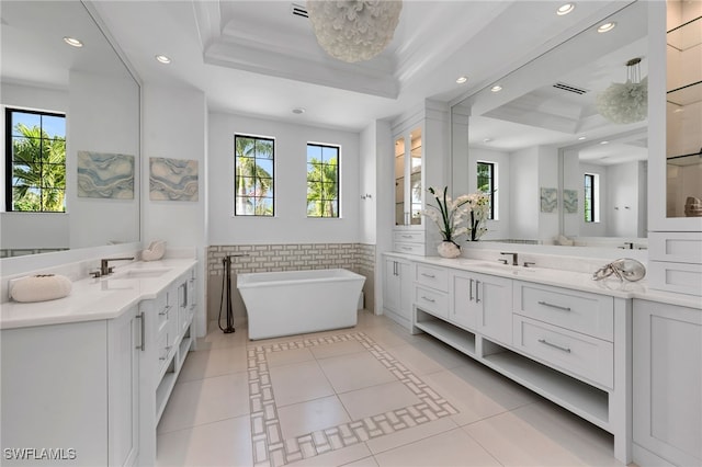 bathroom featuring vanity, tile walls, tile patterned flooring, a raised ceiling, and a washtub