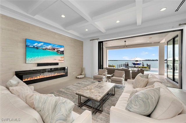 cinema room with ceiling fan, a large fireplace, beamed ceiling, and coffered ceiling