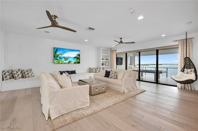 living room with ceiling fan and light hardwood / wood-style flooring