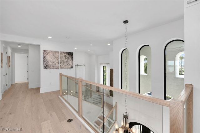 hallway featuring light wood-type flooring and a chandelier