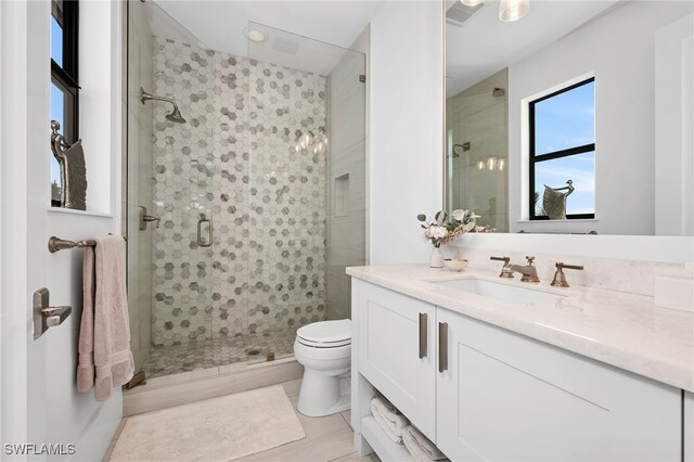 bathroom featuring an enclosed shower, vanity, toilet, and tile patterned flooring