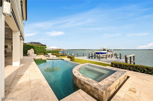 view of swimming pool featuring an in ground hot tub, a patio area, a boat dock, and a water view