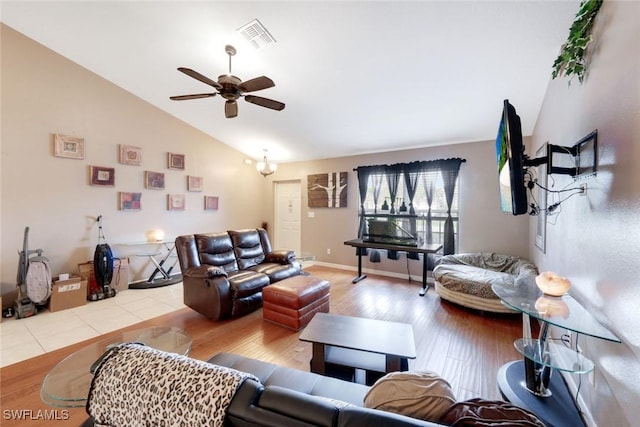 living area featuring visible vents, baseboards, vaulted ceiling, wood finished floors, and a ceiling fan