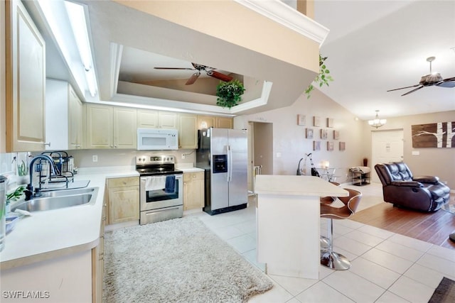 kitchen with ceiling fan with notable chandelier, a sink, open floor plan, appliances with stainless steel finishes, and light tile patterned flooring