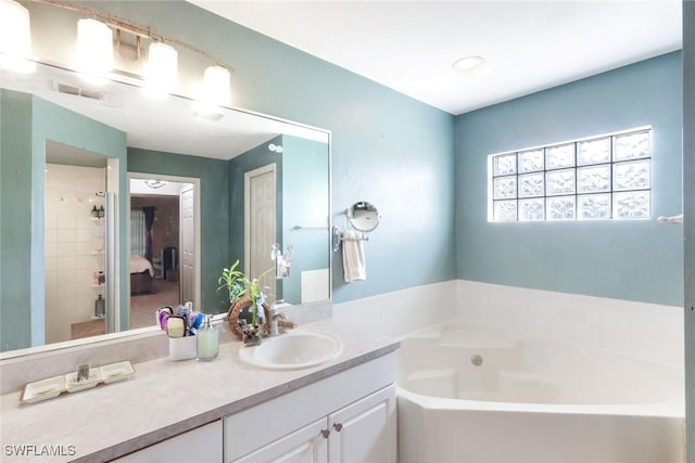 bathroom with visible vents, a garden tub, and vanity