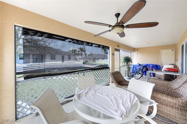 sunroom / solarium featuring a ceiling fan