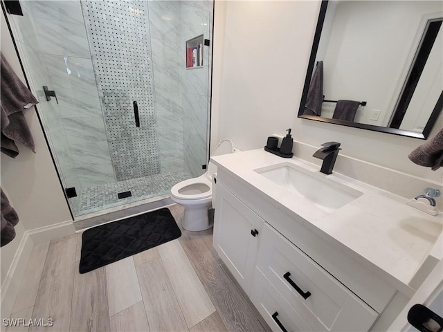 bathroom with toilet, vanity, and a shower with door