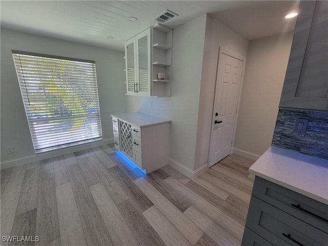 kitchen with white cabinets, gray cabinets, and light wood-type flooring