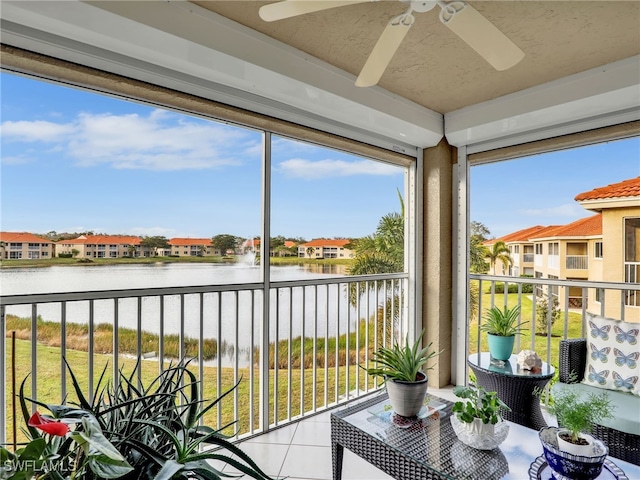 sunroom / solarium with a water view and ceiling fan