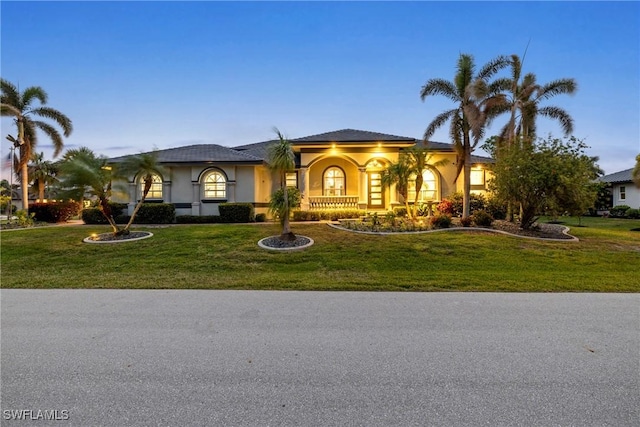 mediterranean / spanish-style house with stucco siding and a front lawn