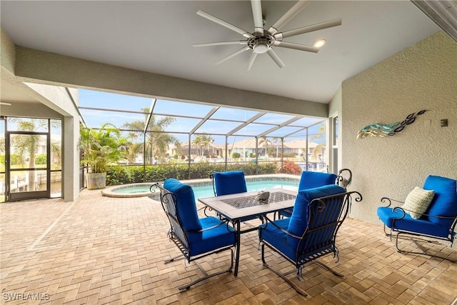 view of patio / terrace with a ceiling fan, glass enclosure, an in ground hot tub, and a fenced in pool