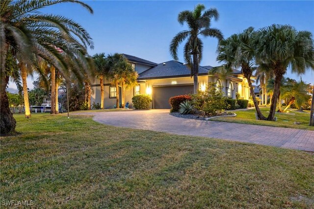 view of front of property featuring a garage and a lawn