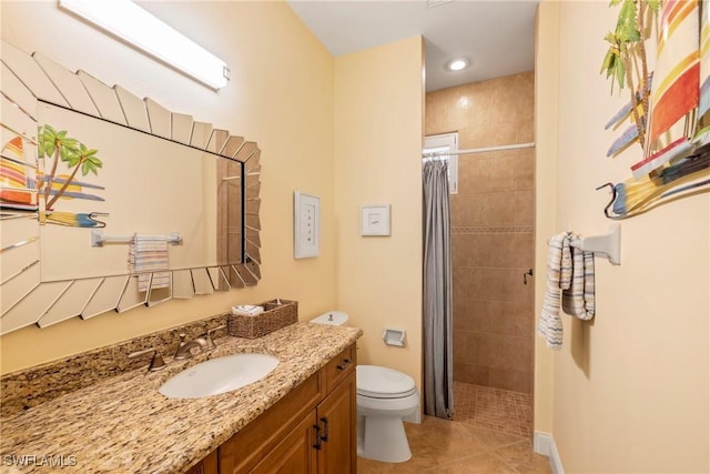 bathroom featuring tile patterned floors, toilet, tiled shower, and vanity