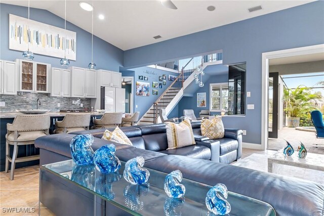 living room with lofted ceiling, light tile patterned floors, and sink