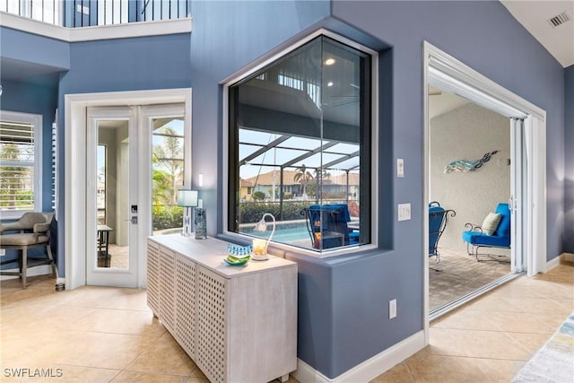 interior space featuring light tile patterned flooring, visible vents, and a wealth of natural light