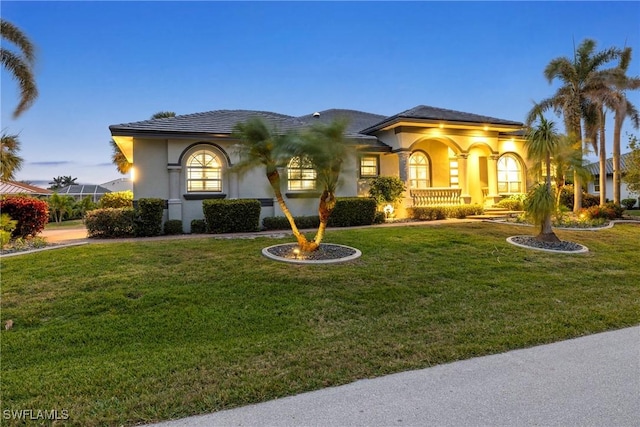 mediterranean / spanish house featuring stucco siding and a front lawn