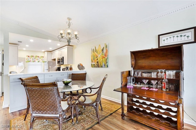 2888 Oleander St Unit C6, Saint James City, FL 33956 - dining space featuring light hardwood / wood-style floors, crown molding, and a chandelier