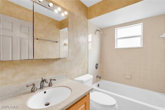 full bathroom featuring toilet, tiled shower / bath, and vanity