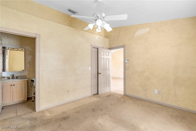 unfurnished bedroom with ceiling fan, sink, and light carpet