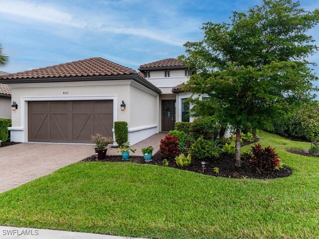 mediterranean / spanish-style house featuring a garage and a front yard