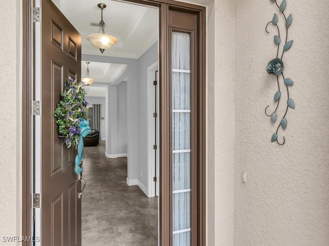 entrance foyer featuring baseboards, crown molding, and a textured wall