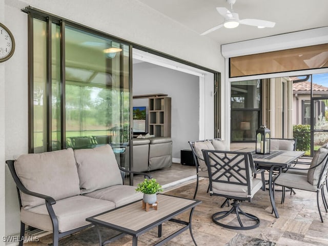 sunroom featuring outdoor lounge area, outdoor dining space, and a ceiling fan