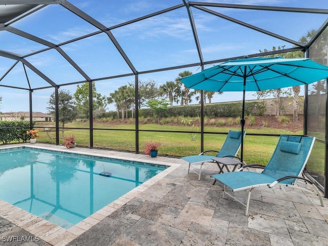 pool with a patio, glass enclosure, and a lawn