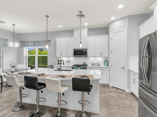 kitchen featuring visible vents, a sink, light countertops, appliances with stainless steel finishes, and tasteful backsplash