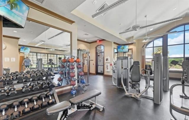 gym featuring visible vents, baseboards, ornamental molding, and a ceiling fan