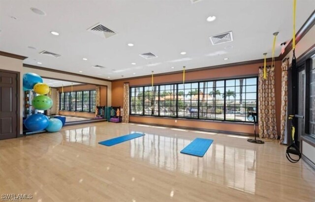 exercise area featuring recessed lighting, visible vents, and ornamental molding