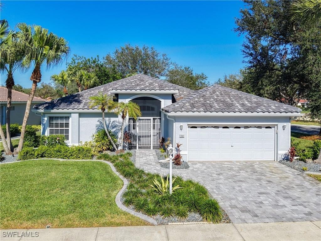 view of front of property featuring a front lawn and a garage