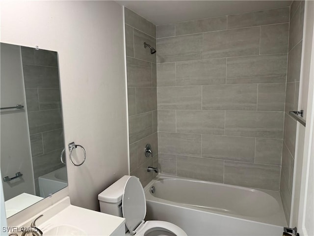 full bathroom featuring tiled shower / bath combo, vanity, and toilet