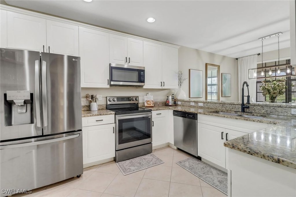 kitchen featuring light stone countertops, sink, white cabinets, and appliances with stainless steel finishes