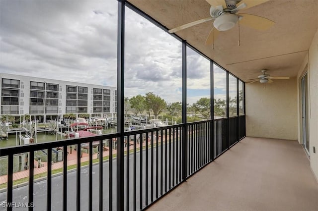 balcony featuring ceiling fan and a water view