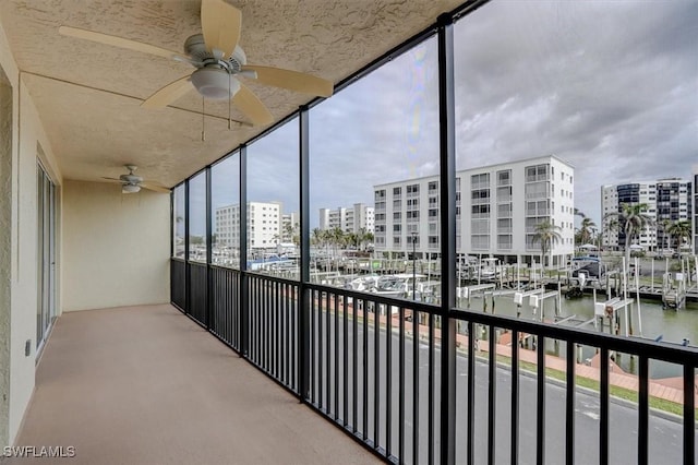 balcony with ceiling fan and a water view