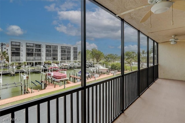 unfurnished sunroom featuring a water view and ceiling fan