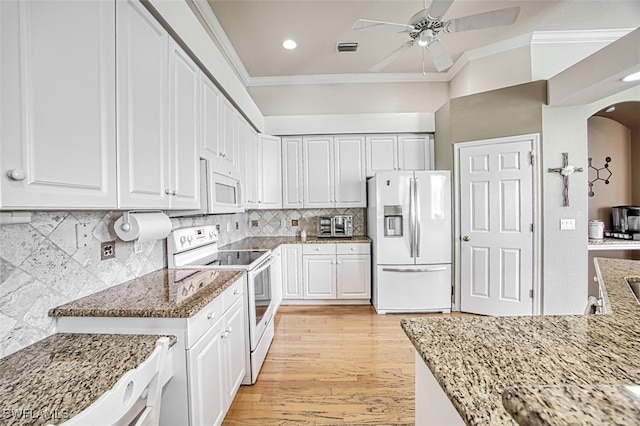 kitchen featuring white appliances, white cabinetry, backsplash, light stone counters, and crown molding