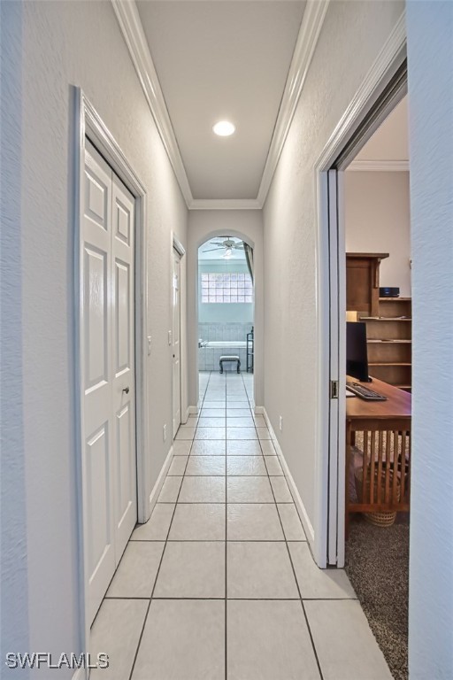 hall with light tile patterned floors and ornamental molding