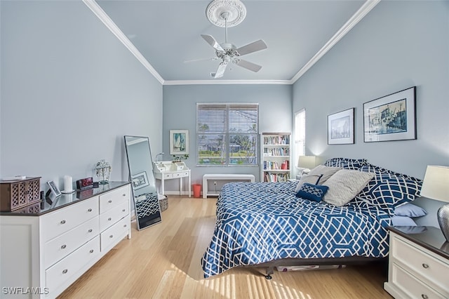 bedroom with ceiling fan, crown molding, and light hardwood / wood-style floors