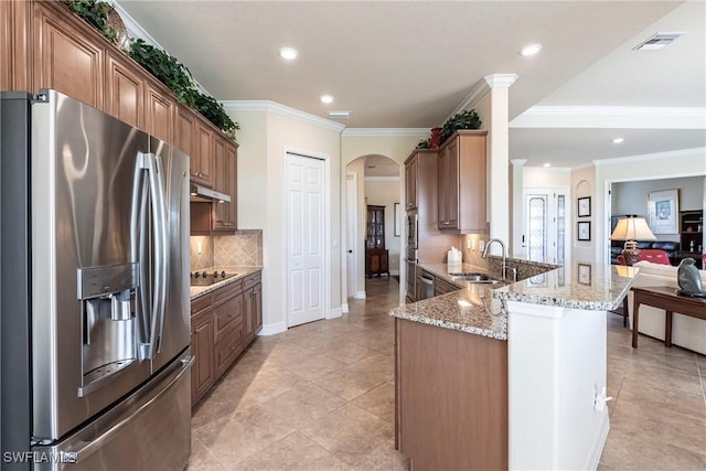 kitchen with sink, stainless steel refrigerator with ice dispenser, black electric stovetop, light stone countertops, and decorative backsplash