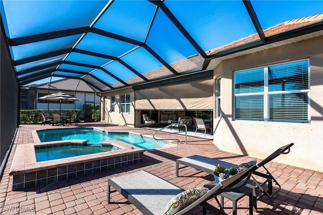 view of pool featuring a lanai, a patio area, and an in ground hot tub