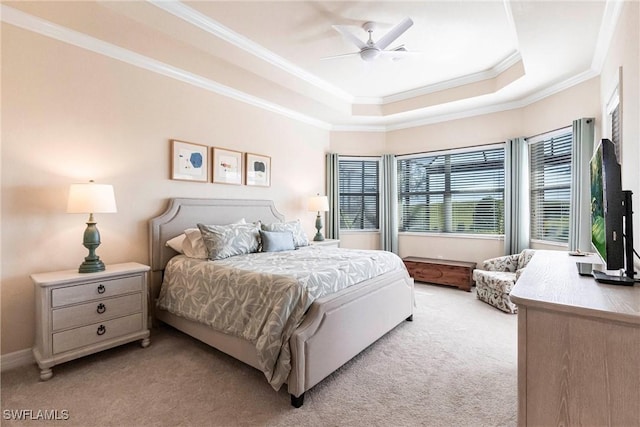 bedroom featuring a tray ceiling, ornamental molding, light colored carpet, and ceiling fan