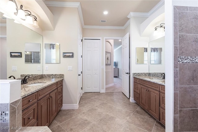 bathroom featuring a sink, baseboards, two vanities, and crown molding