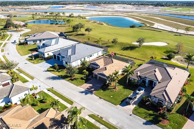 aerial view featuring golf course view, a residential view, and a water view