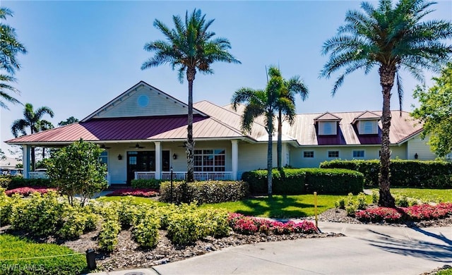 view of front facade featuring a standing seam roof, covered porch, and metal roof