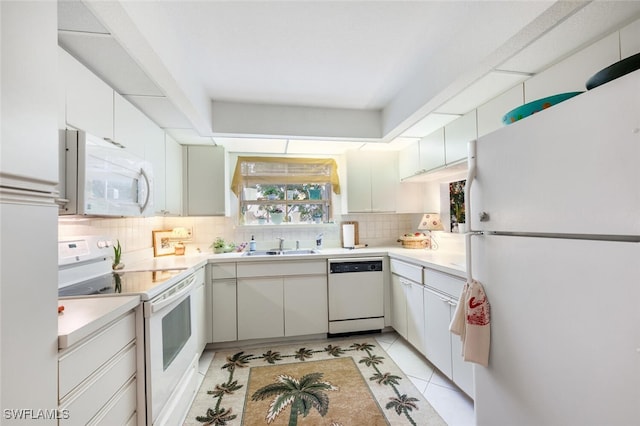 kitchen featuring sink, backsplash, white appliances, and white cabinetry