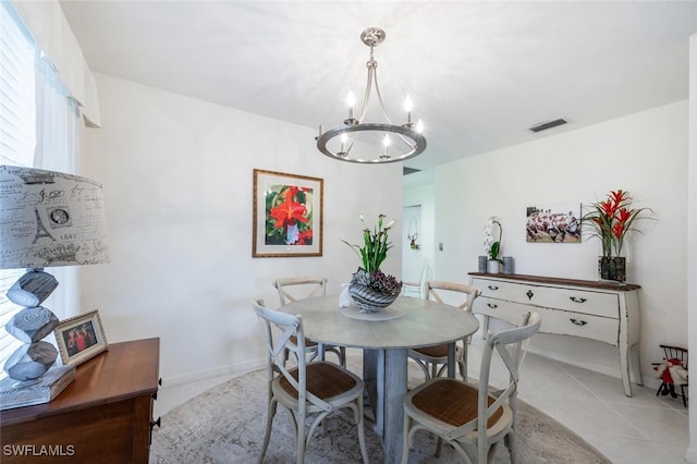 dining area featuring light tile patterned floors and a notable chandelier