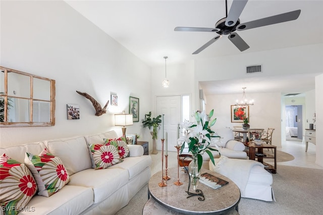 living room with ceiling fan with notable chandelier and light colored carpet